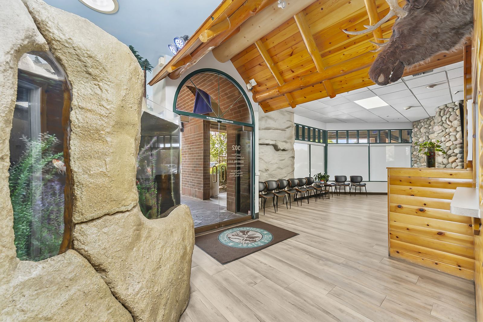 Front entry with the practice logo mat under a log-beam ceiling